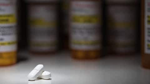 White pills in front of prescription bottles