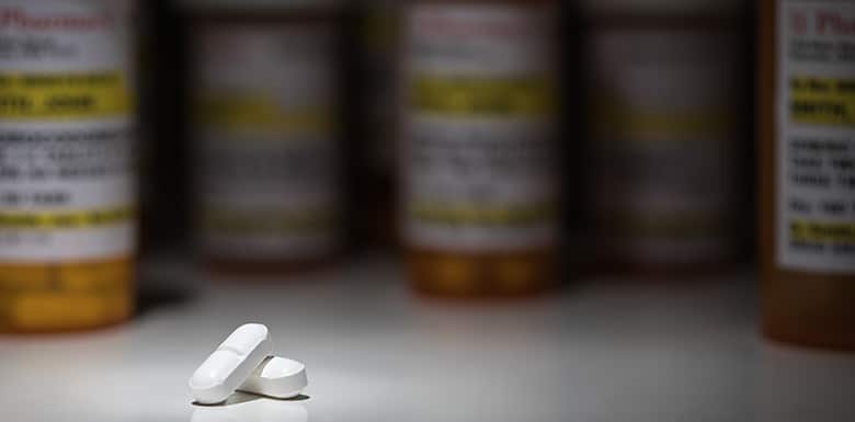 White pills in front of prescription bottles