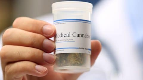 Man holding container of medical cannabis