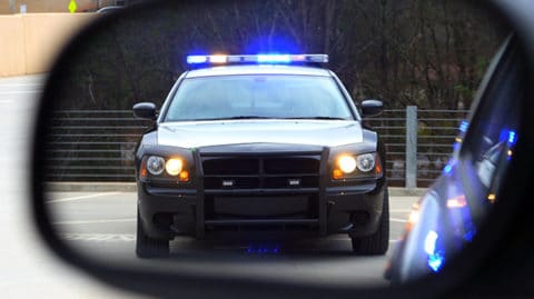 Police car with lights in rear view mirror