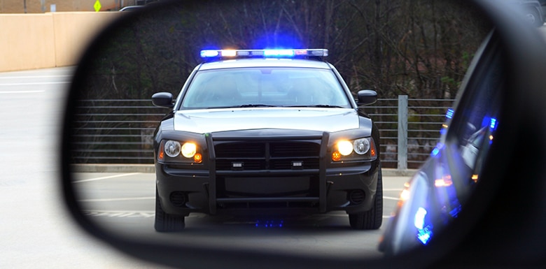 Police car with lights in rear view mirror