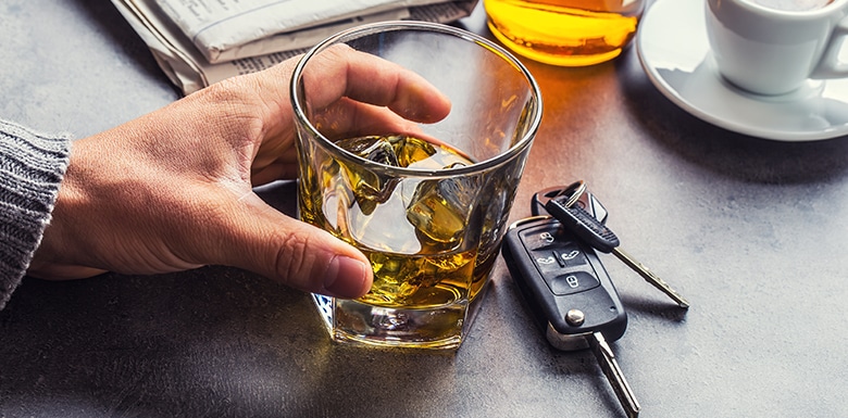 Holding glass of alcohol and car keys