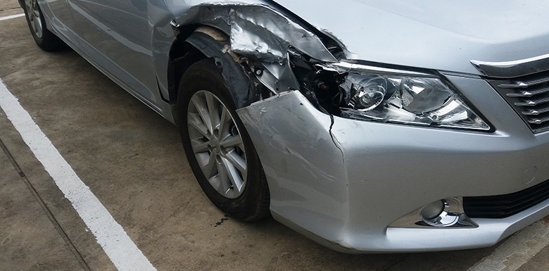 Silver car with busted headlight