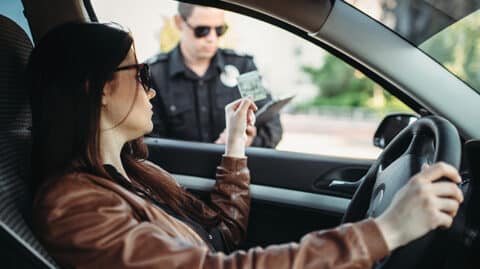 Driver handing over ID to police through window