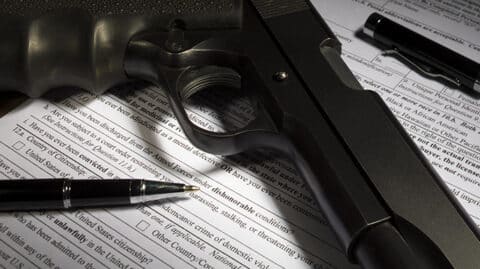 Black gun resting on blank firearm registration form