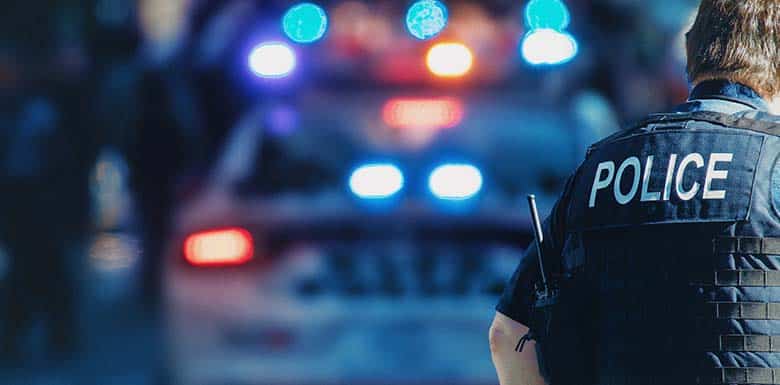 Police officer in front of his car