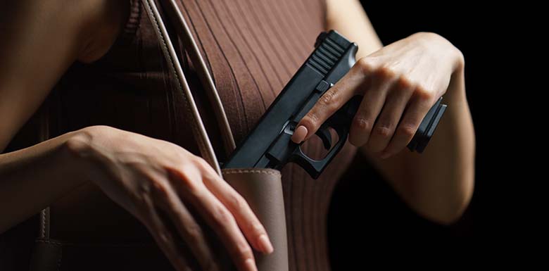 Woman putting gun into purse