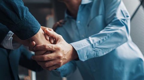 Person shaking hands with man in a suit