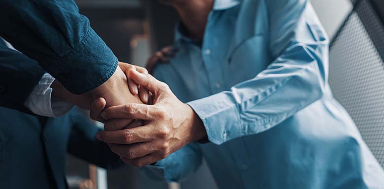 Person shaking hands with man in a suit